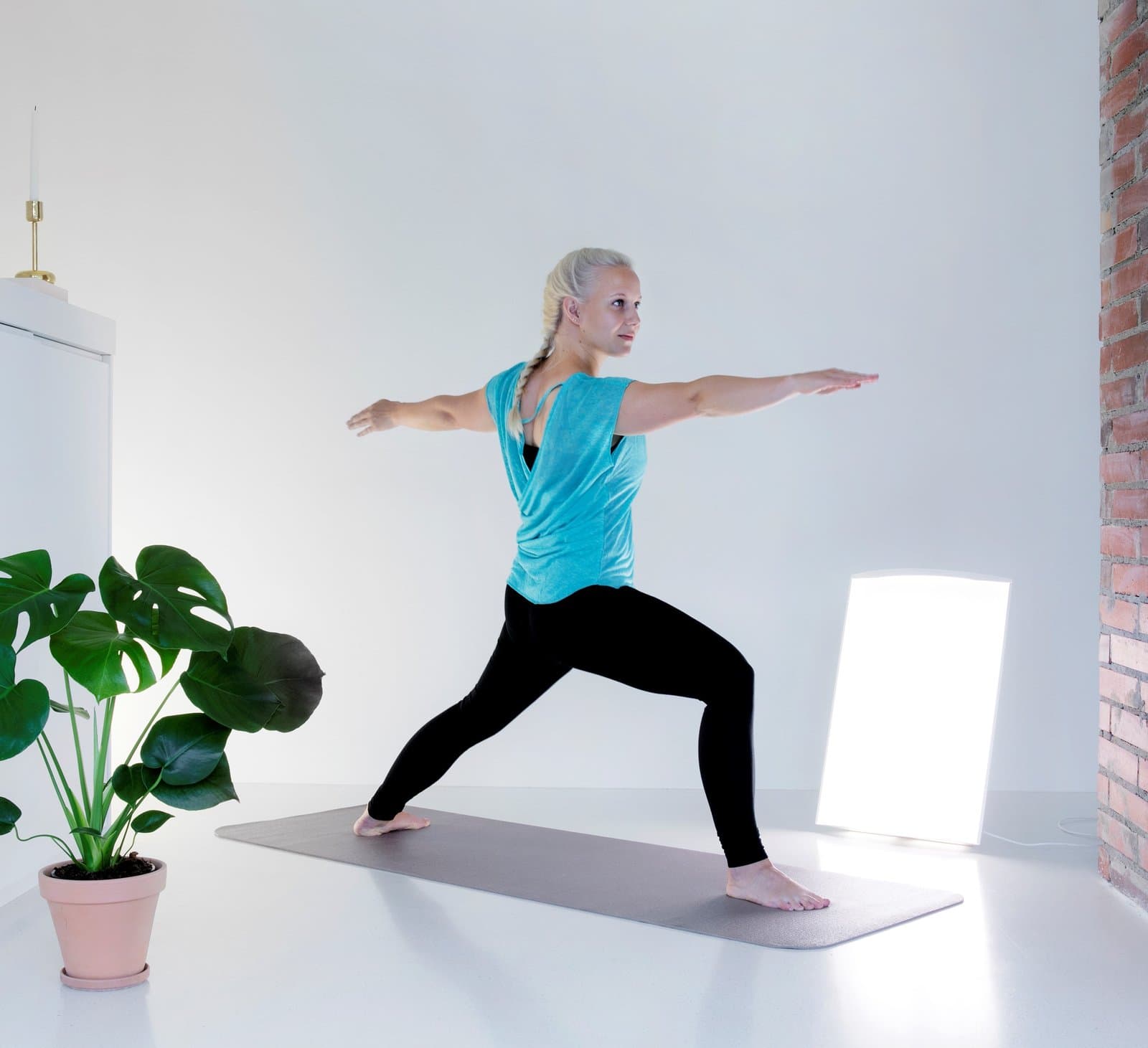Frau macht Yoga vor der Supernova LED in einem hellen Raum